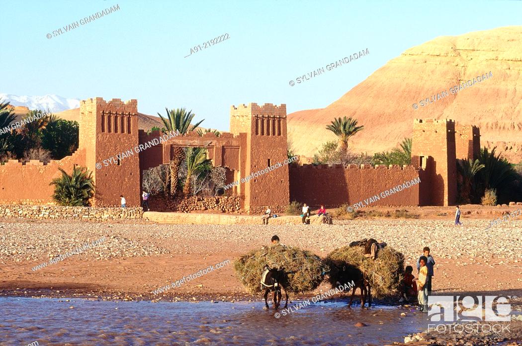 Stock Photo: MOROCCO.SOUTH.OUARZAZATE REGION.AIT BENHADDU ""KSAR"" RUINS (ANCIENT ADOBE FORTRESS AND VILLAGE).PEASANTS CROSSING THE RIVER (""OUED"").