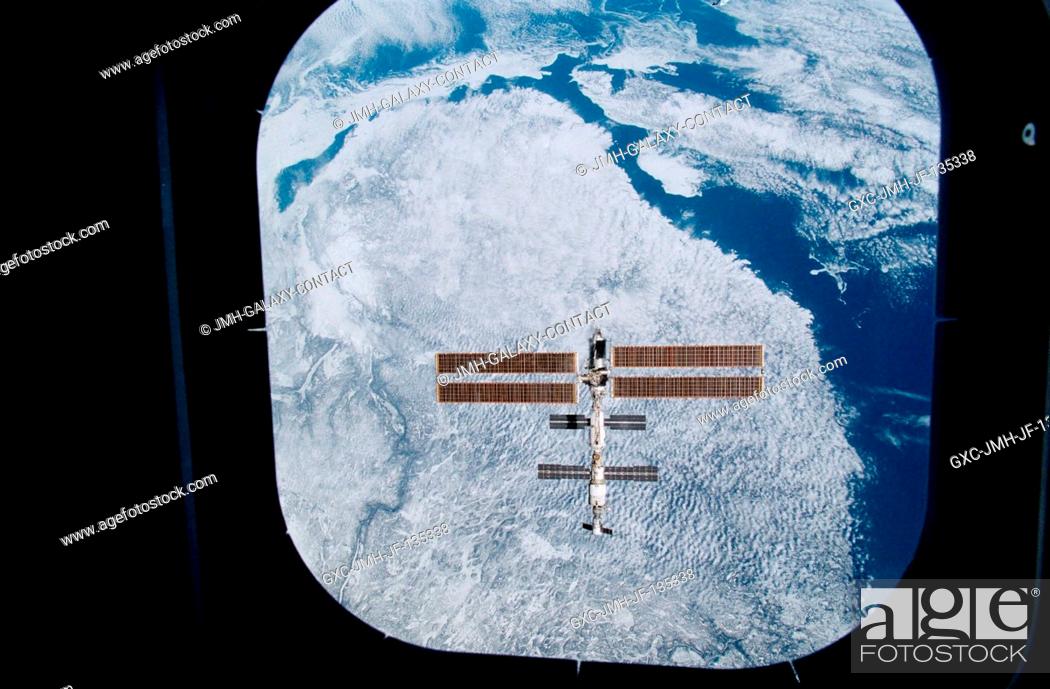 Stock Photo: Backdropped against the topography of the Canadian province of Quebec, the International Space Station (ISS) was photographed through an aft flight deck window.