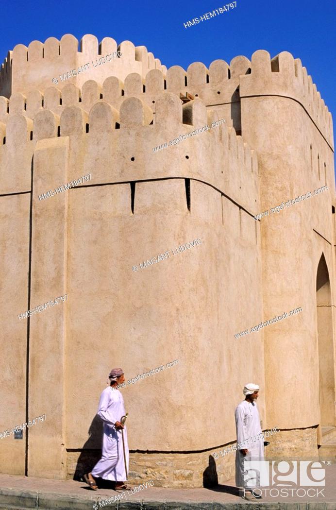 Stock Photo: Oman, Nizwa, Omani man in front of the 17th century Fort.