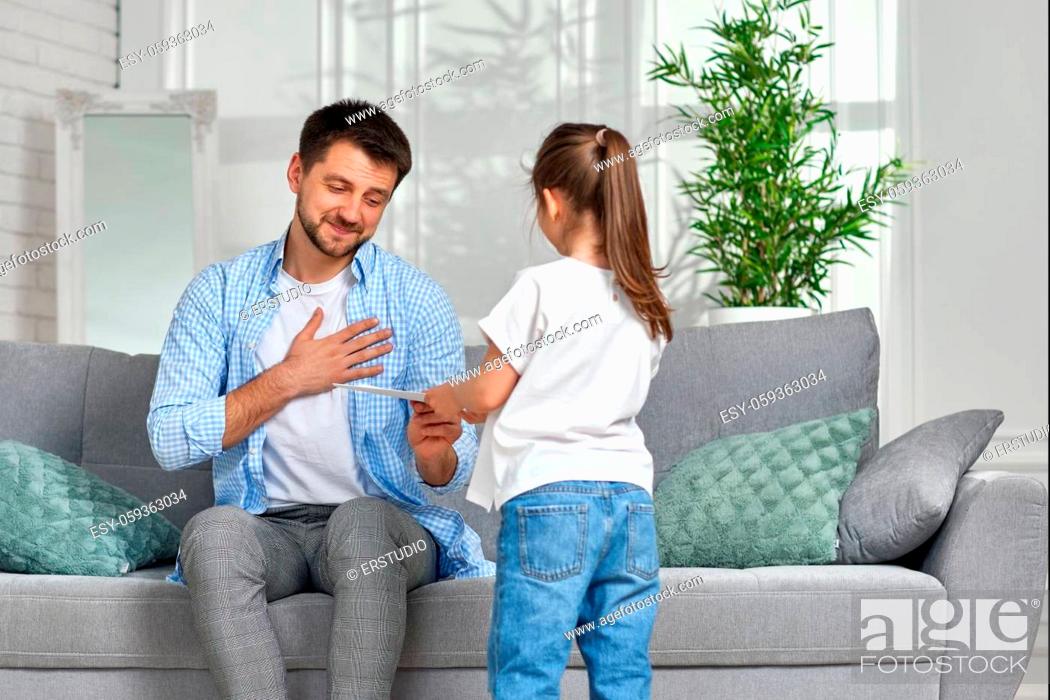 Stock Photo: cute child daughter congratulates her happy father and gives him greeting card. father's day.