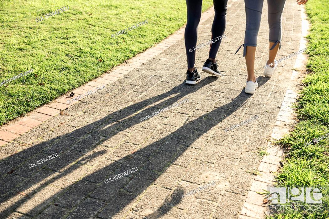 Stock Photo: Legs and shadow of couple on path.