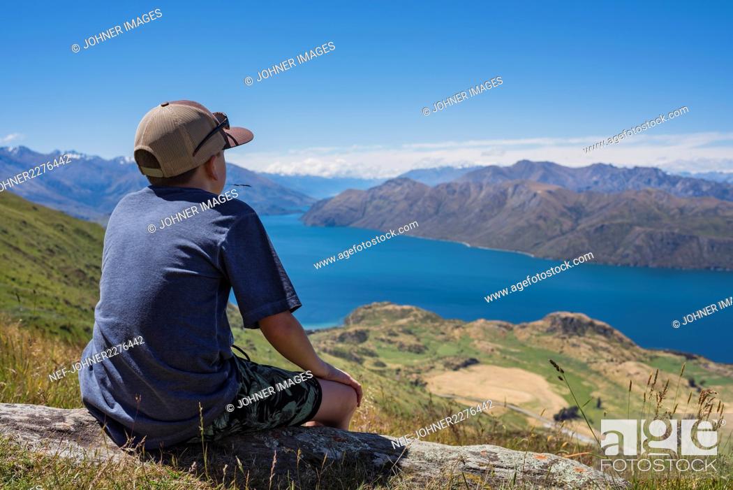 Stock Photo: Boy looking at lake in mountains.
