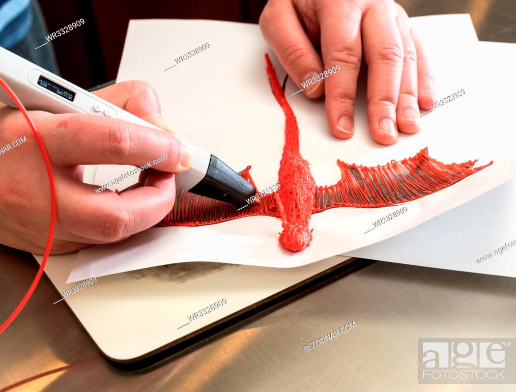 Stock Photo: 3D printing pen working by melting ABS plastic to create a model of a dragon.