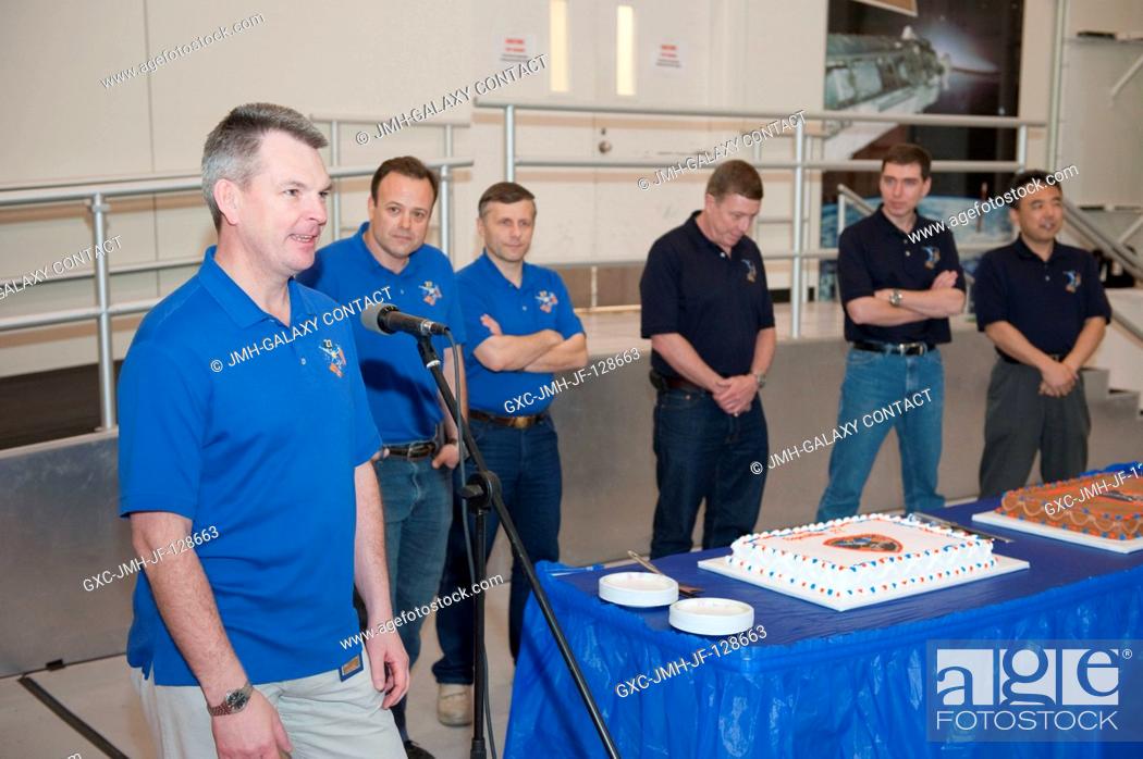 Stock Photo: Russian cosmonaut Alexander Samokutyaev (left foreground), Expedition 2728 flight engineer, speaks to a crowd during a cake-cutting ceremony in the Jake Garn.