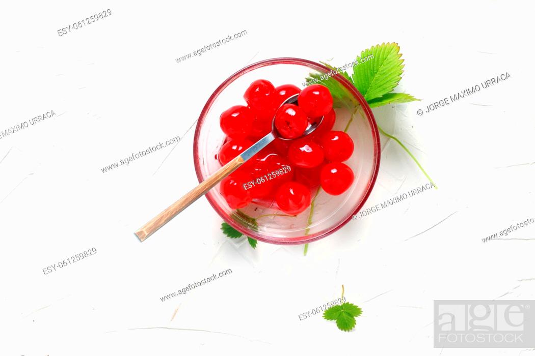 Stock Photo: Cherries in syrup in bowl on white background.