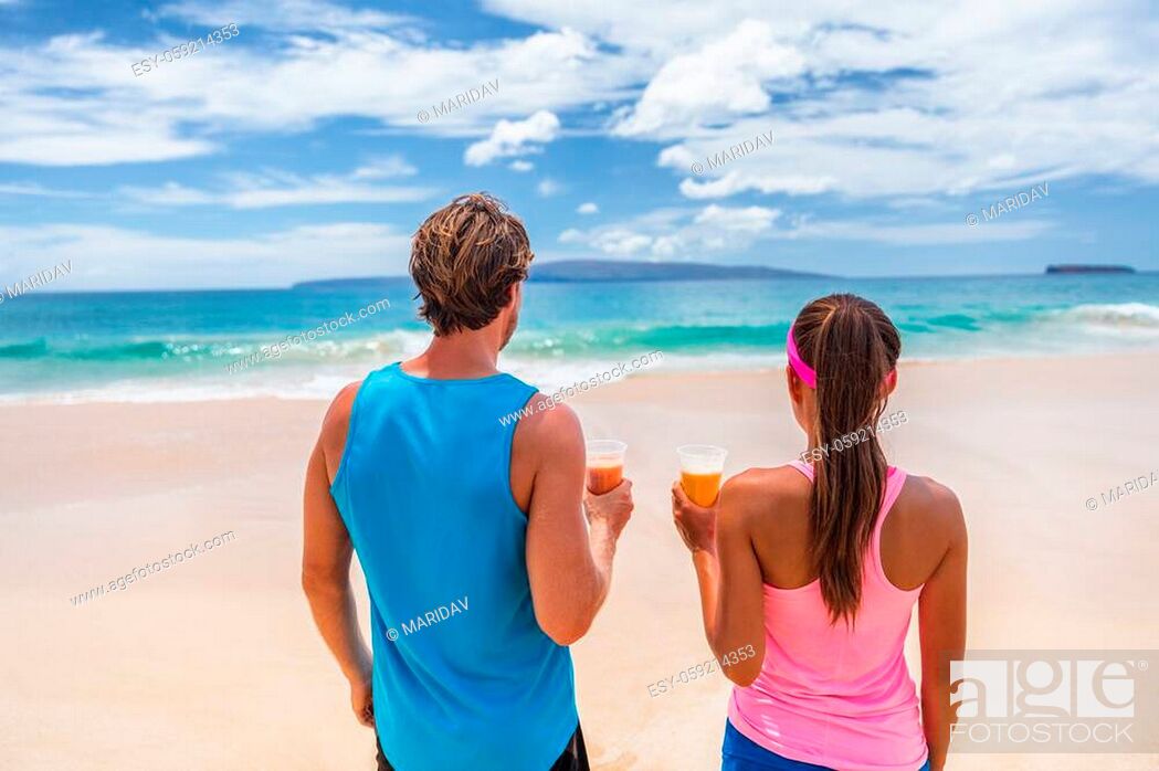 Stock Photo: Healthy people active lifestyle. Fitness runners couple on beach drinking breakfast fruit juice in smoothie cups looking at ocean. Summer background.