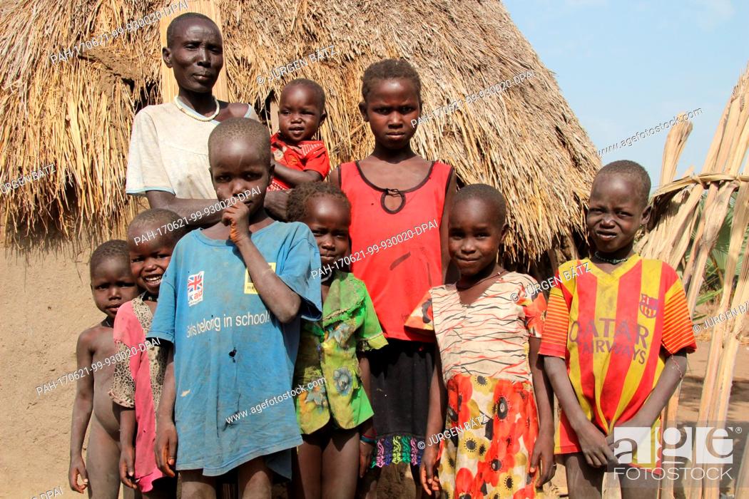 Stock Photo: Internally displaced Nyakume Wuor Gai stands together with her own children and neighbour's children in front of a shed on an island near Nyal at the federal.