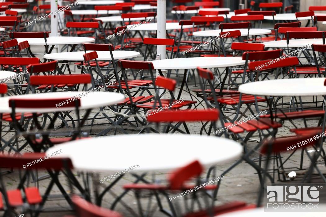 Stock Photo: 18 May 2021, North Rhine-Westphalia, Cologne: Empty tables and chairs stand in front of a restaurant. The incidence of new corona infections in North.