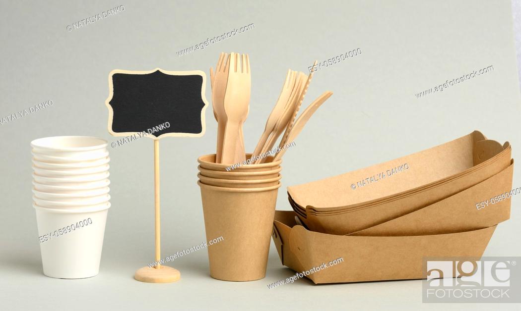 Stock Photo: disposable brown, white paper cups, rectangular plates and wooden forks on a gray background. Zero waste, no plastic.