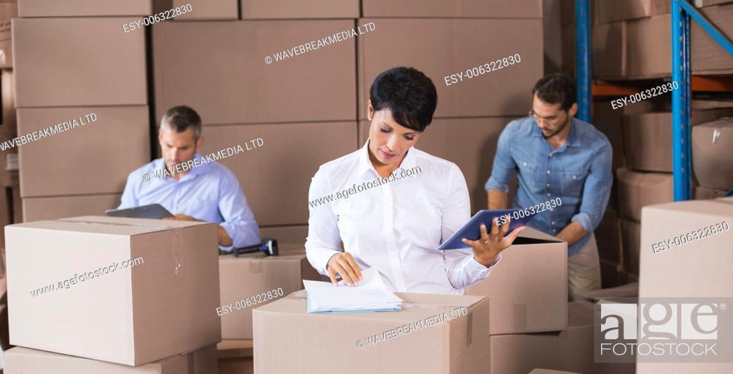 Stock Photo: Warehouse workers preparing a shipment in a large warehouse.