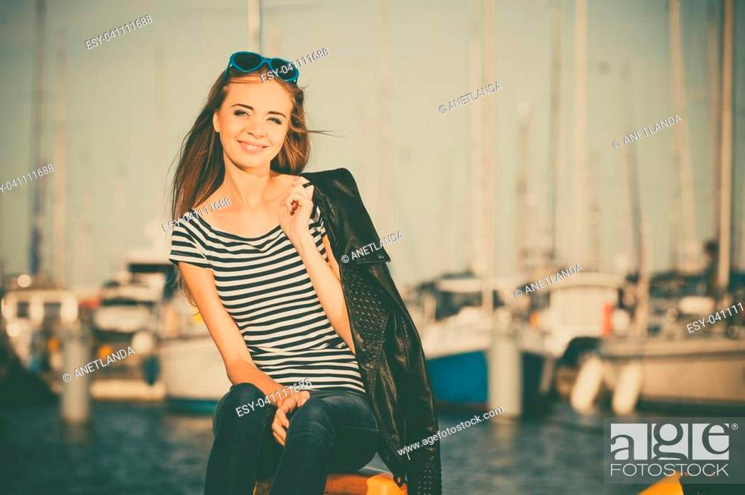 Stock Photo: Tourism relax and people concept. Fashion blonde girl with blue heart shaped sunglasses in marina against yachts in port.