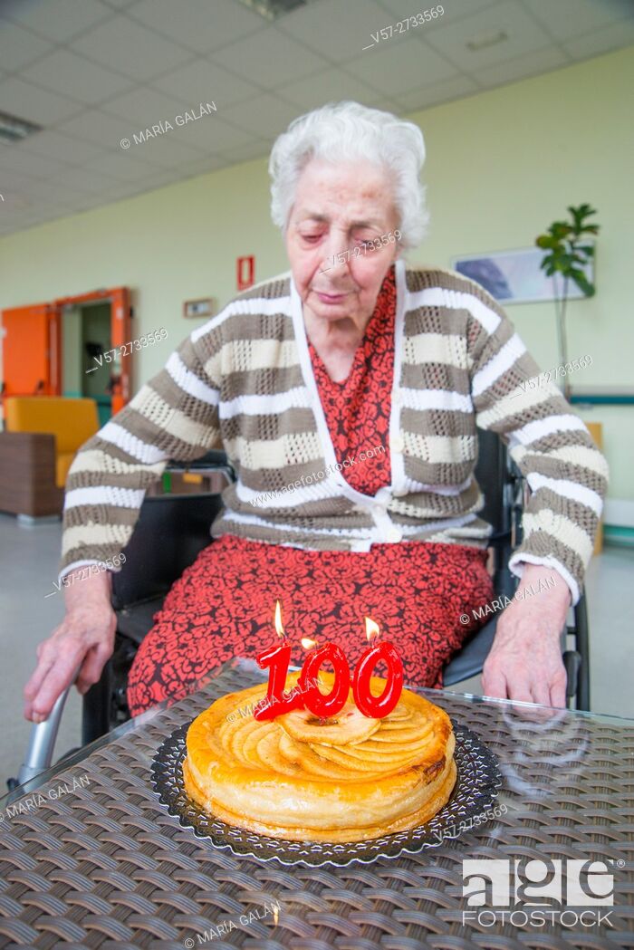 Photo de stock: Old woman in a nursing home, on her one hundred birthday, blowing birthday's candles.