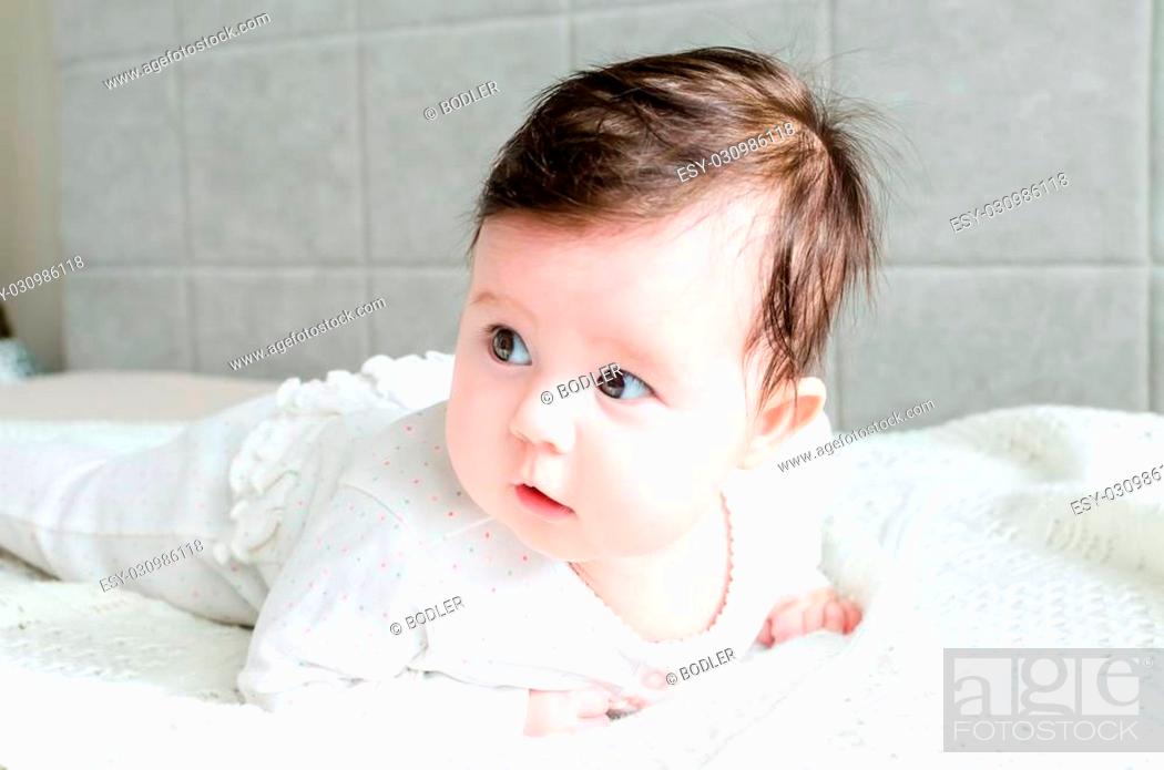 Cute sweet little newborn baby girl with black brunette hair in nice white  spotted romper suit..., Stock Photo, Picture And Low Budget Royalty Free  Image. Pic. ESY-030986118 | agefotostock