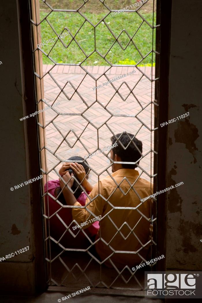 Stock Photo: Boy and girl sitting near at metal jail of Lalbagh fort ; Dhaka ; Bangladesh.