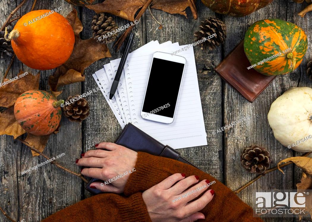 Stock Photo: Smartphone with blank screen for copy space and notepad on wooden table with pumpkins, fall colorful leaves, autumn composition, Thanksgiving, concept.
