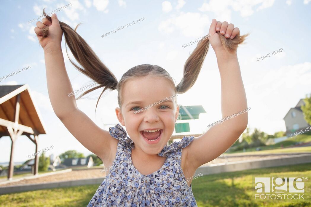 Photo de stock: Caucasian girl playing with pigtails outdoors.