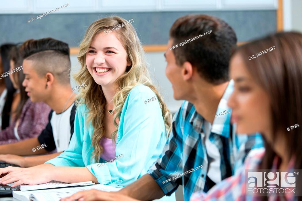 Stock Photo: Row of teenage high school students smiling in computer class.