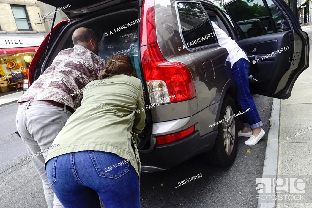 Stock Photo: Hudson, New York, USA Three people working to pack a car.