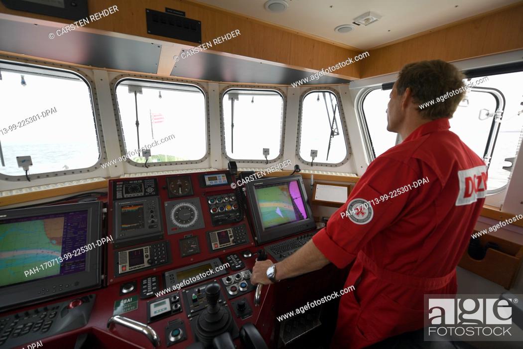 Stock Photo: Foreman Joerg Luedtke steers the rescue cruiser 'Theodor Storm' on the North Sea off Buesum,  Germany, 11 July 2017. The German Maritime Search and Rescue.