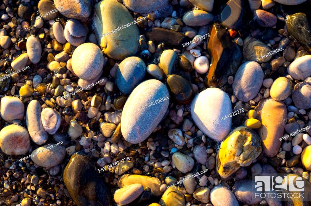 Stock Photo: sea pebble beach with multicoloured stones, transparent waves with foam, on a warm summer day.