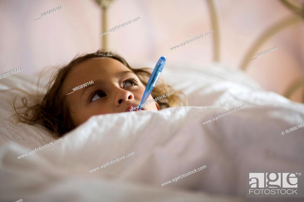 Stock Photo: High angle view of a girl with a thermometer in her mouth.