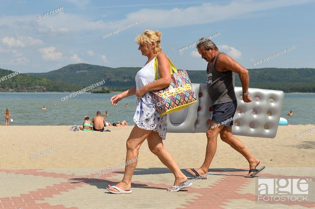 Stock Photo: The series of tropical days continues in the Czech Republic with temperatures of up to 38 degrees Centigrade and people enjoy sun bathing and swimming in Lake.