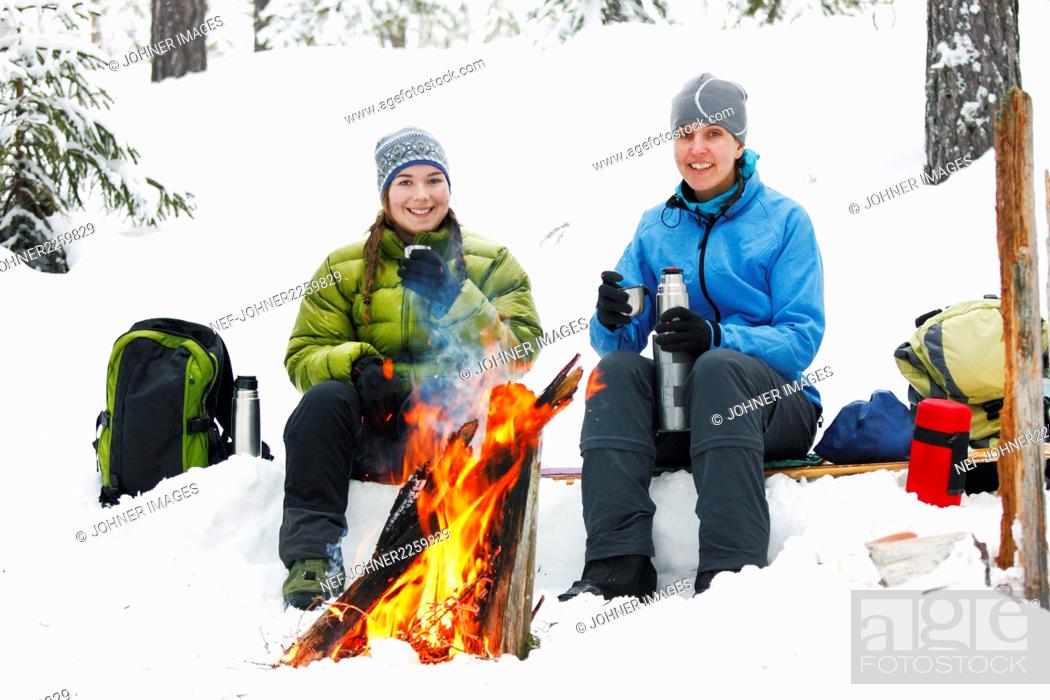 Stock Photo: Women resting by fireplace in winter forest.