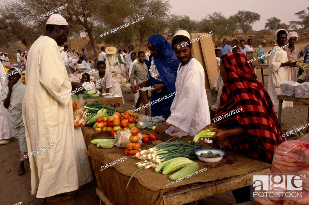 Stock Photo: Fruit and vegetable stall at outside market with vendors and male customer.
