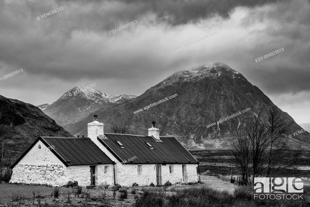 Stock Photo: Epic black and white dramatic landscape image of Buachaille Etive Mor and River Etive in Scottish Highlands on a Winter morning with moody sky and lighting.