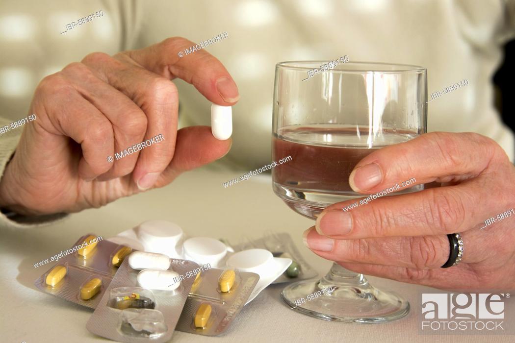 Stock Photo: Woman holding medication pill, France, Europe.