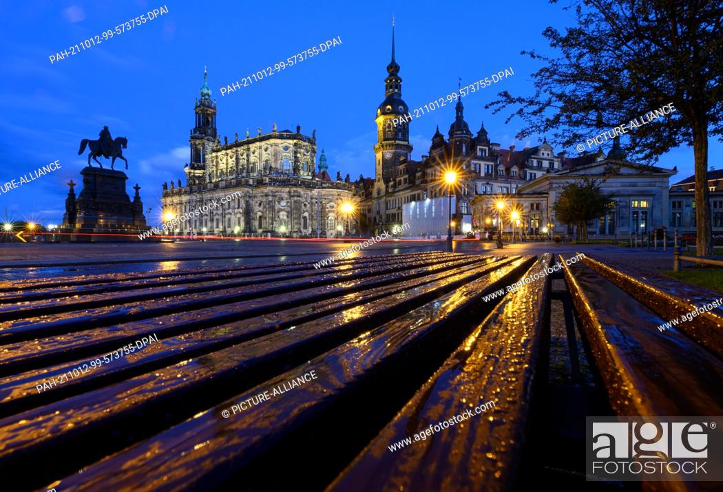 Stock Photo: 12 October 2021, Saxony, Dresden: A bench on the Theaterplatz with the equestrian statue of King Johann (l-r), the Hofkirche, the Hausmannsturm.