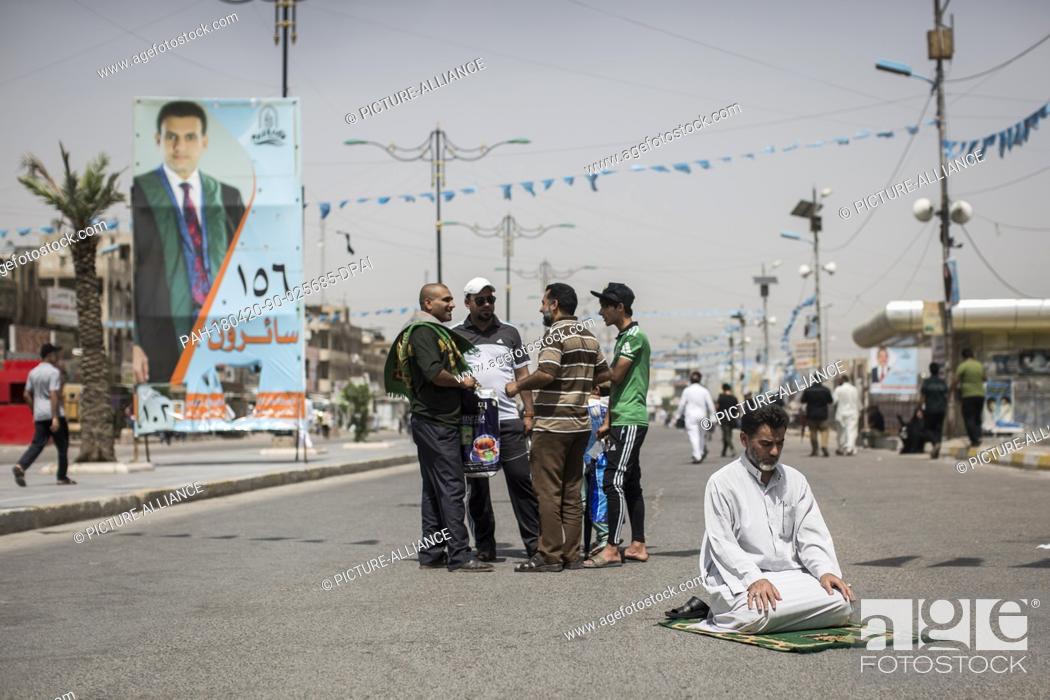Stock Photo: dpatop - An Iraqi man attends Friday prayers backdropped by campaign posters for the upcoming parliamentary elections in the Sadr City suburb of Baghdad, Iraq.