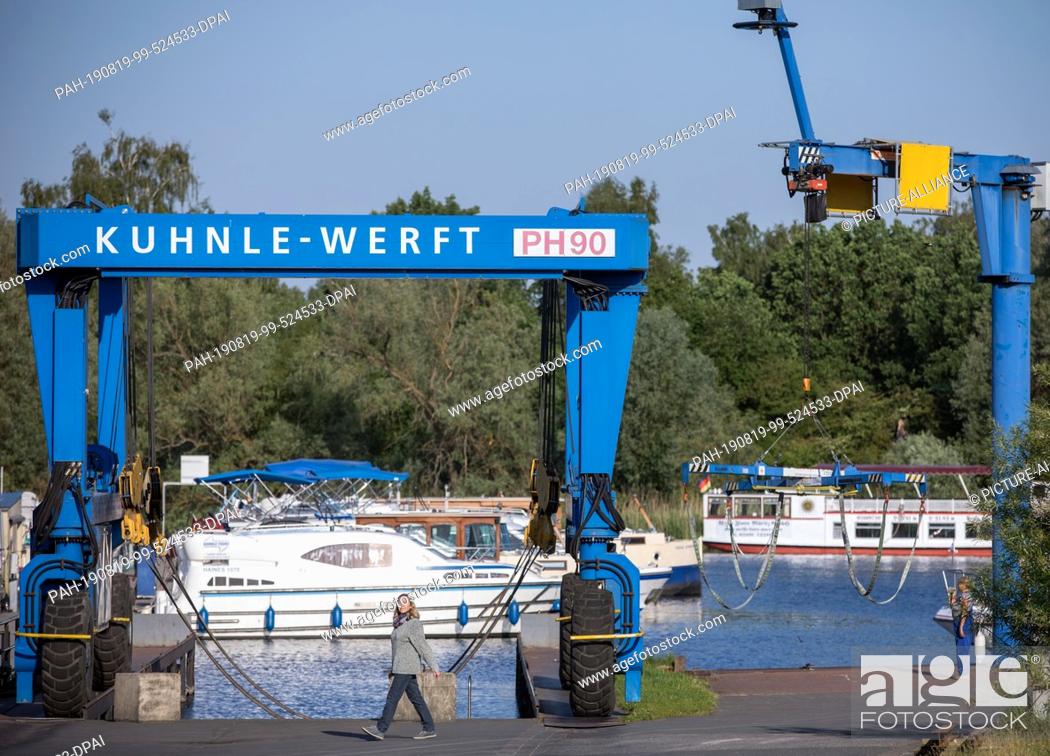 Stock Photo: 25 May 2019, Mecklenburg-Western Pomerania, Rechlin: A houseboat is overhauled in the Kuhnle shipyard shipbuilding hall. The boats intended for charter tours on.
