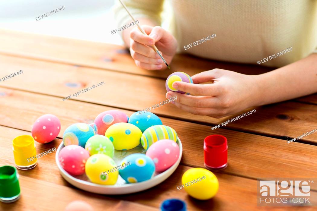 Stock Photo: easter, holidays, tradition and people concept - close up of woman hands coloring easter eggs with colors and brush.