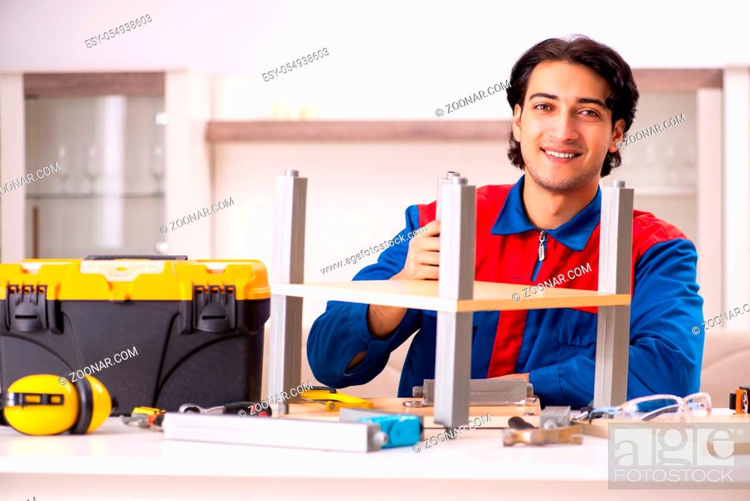 Stock Photo: Young contractor repairing furniture at home.