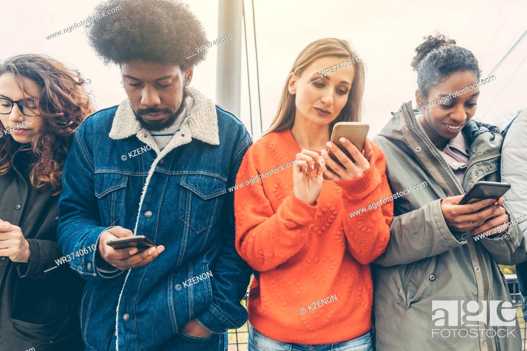 Stock Photo: Group of people choosing their phones over personal interaction.