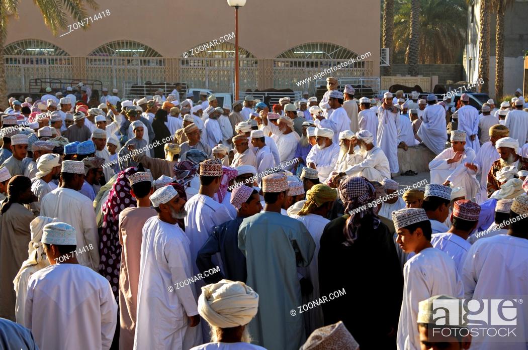 Stock Photo: Massenszene auf dem Viehmarkt, omanischer Männer in der Nationaltracht Dishdasha und der Kummah Kappe oder dem Mussar Turban auf dem Kopf versameln sich auf.