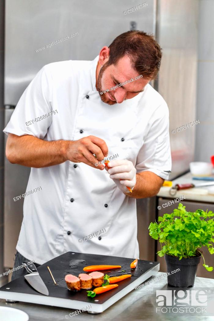 Stock Photo: Chef decorating carrots with parsley.