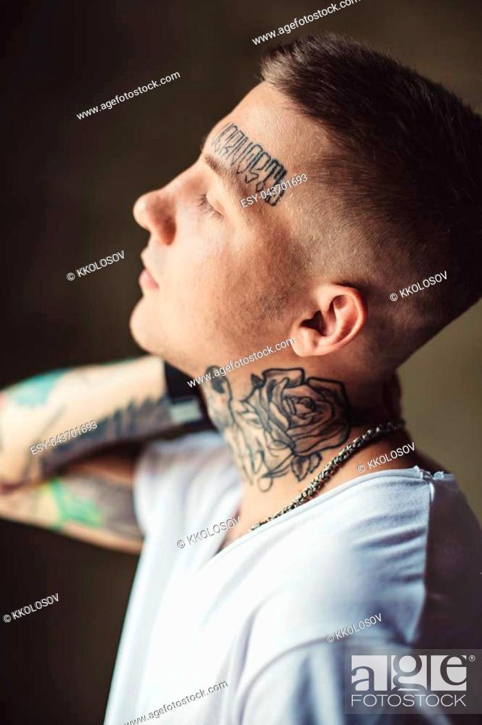 Side view of casual man in white t-shirt showing tattoos on all body while  posing outside, Stock Photo, Picture And Low Budget Royalty Free Image.  Pic. ESY-043701693 | agefotostock