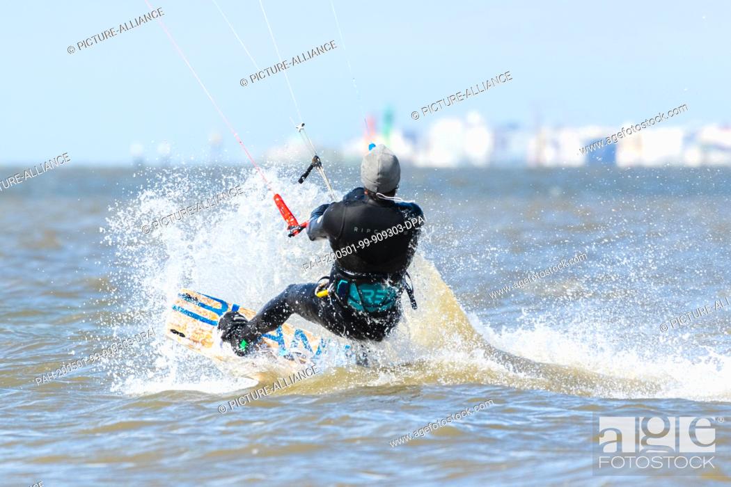 Stock Photo: 01 May 2020, Lower Saxony, Norddeich: Kitesurfer Louis Urfel in the afternoon in the North Sea near Norddeich. Photo: Mohssen Assanimoghaddam/dpa.