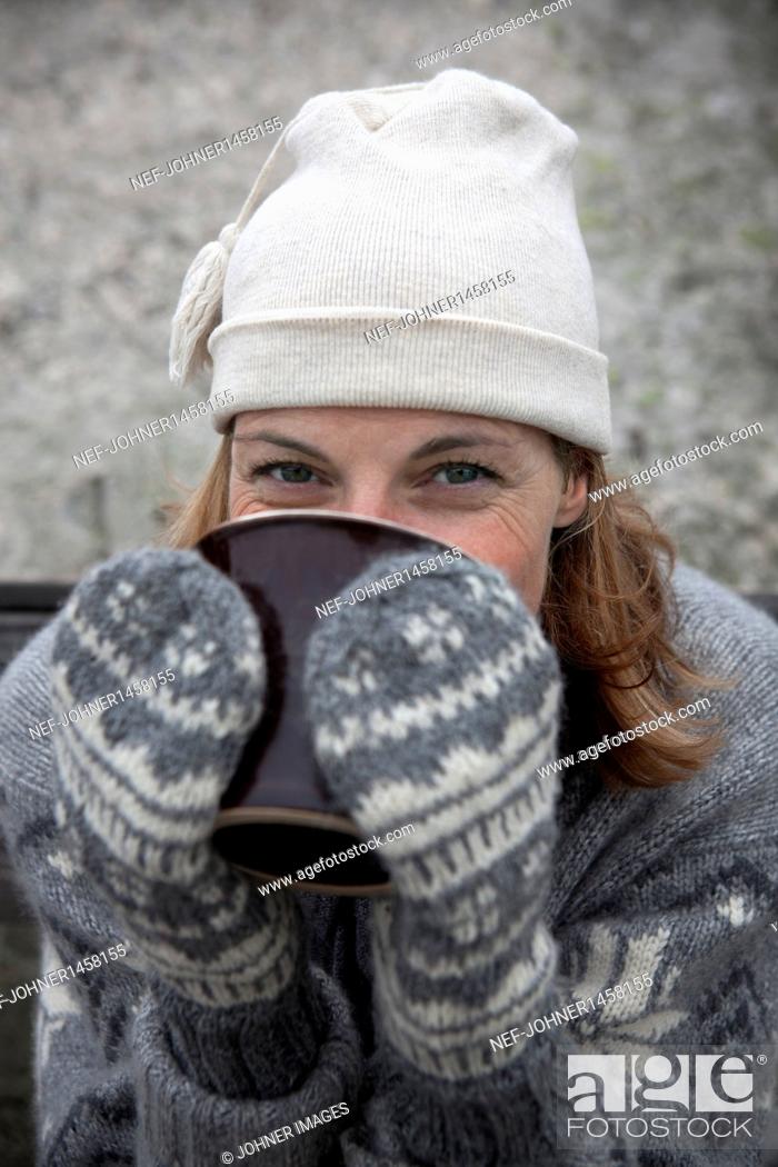 Stock Photo: Portrait of woman wearing warm clothing drinking hot drink.