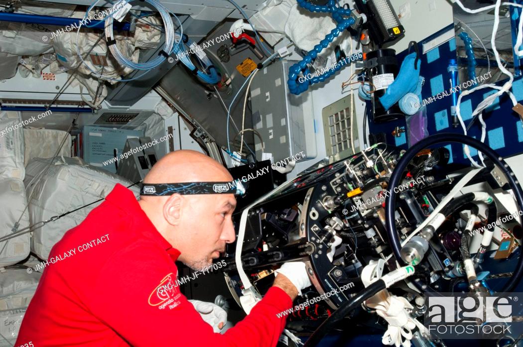 Stock Photo: European Space Agency astronaut Luca Parmitano, Expedition 36 flight engineer, works on the Multi-User Droplet Combustion Apparatus (MDCA) Chamber Insert.