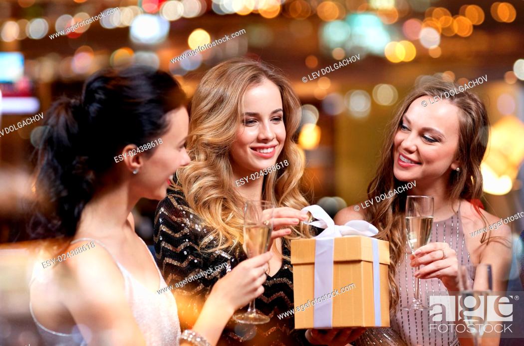 Stock Photo: celebration, friends, bachelorette party, birthday and holidays concept - happy women with champagne glasses and gift box at night club.