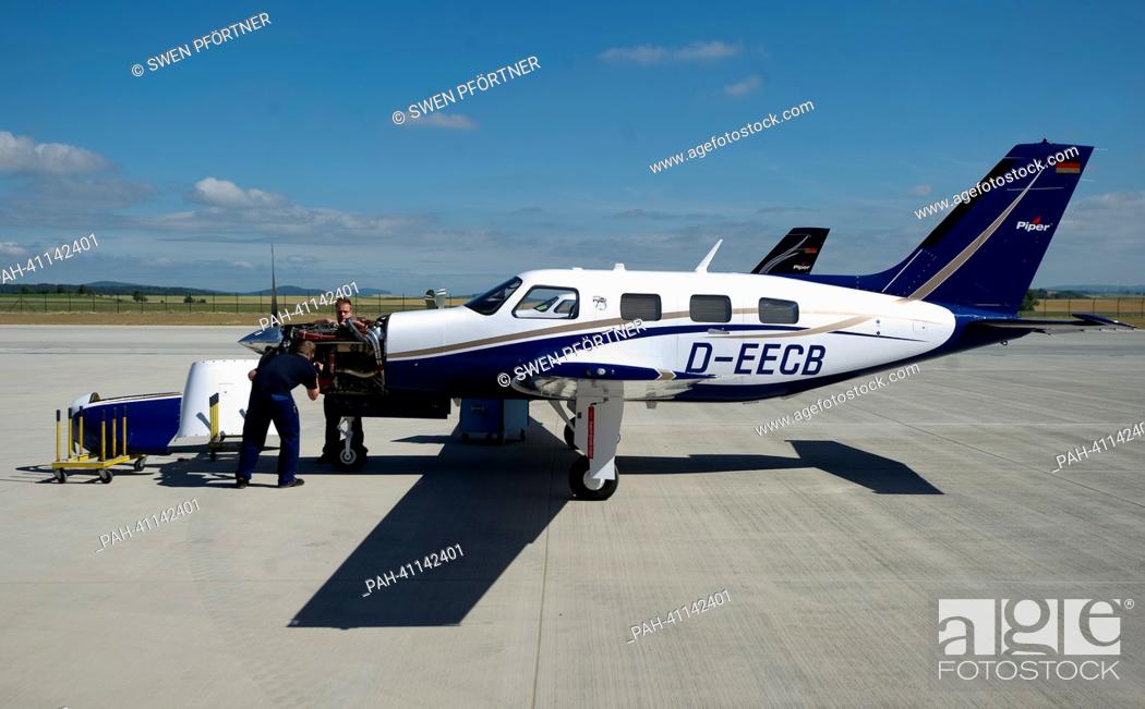 Stock Photo: Two Piper employees check a plane outside of the new Piper building at the airport in Kassel-Calden,  Germany, 19 July 2013.