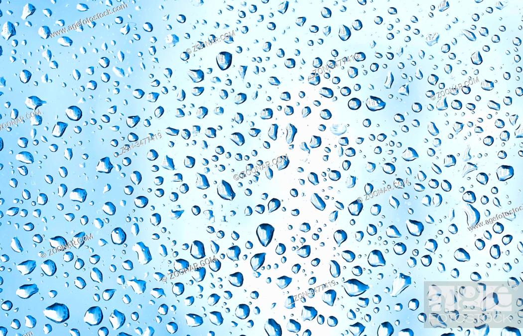 Stock Photo: Many blue water drops on window glass.