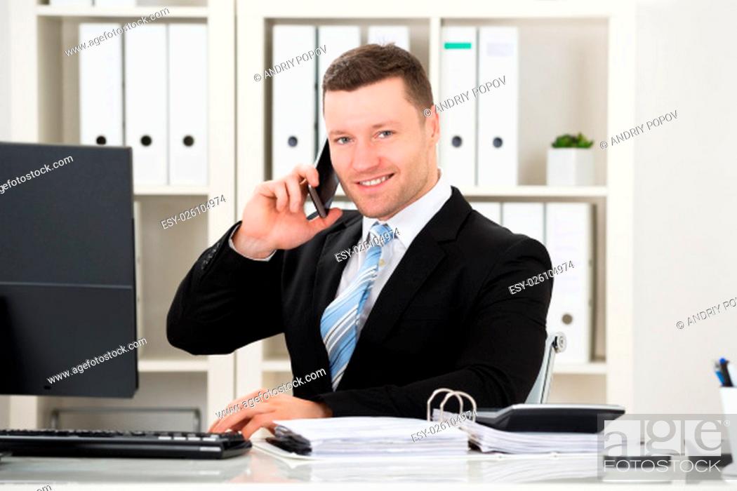 Stock Photo: Portrait of confident accountant with calculator and documents at desk in office.