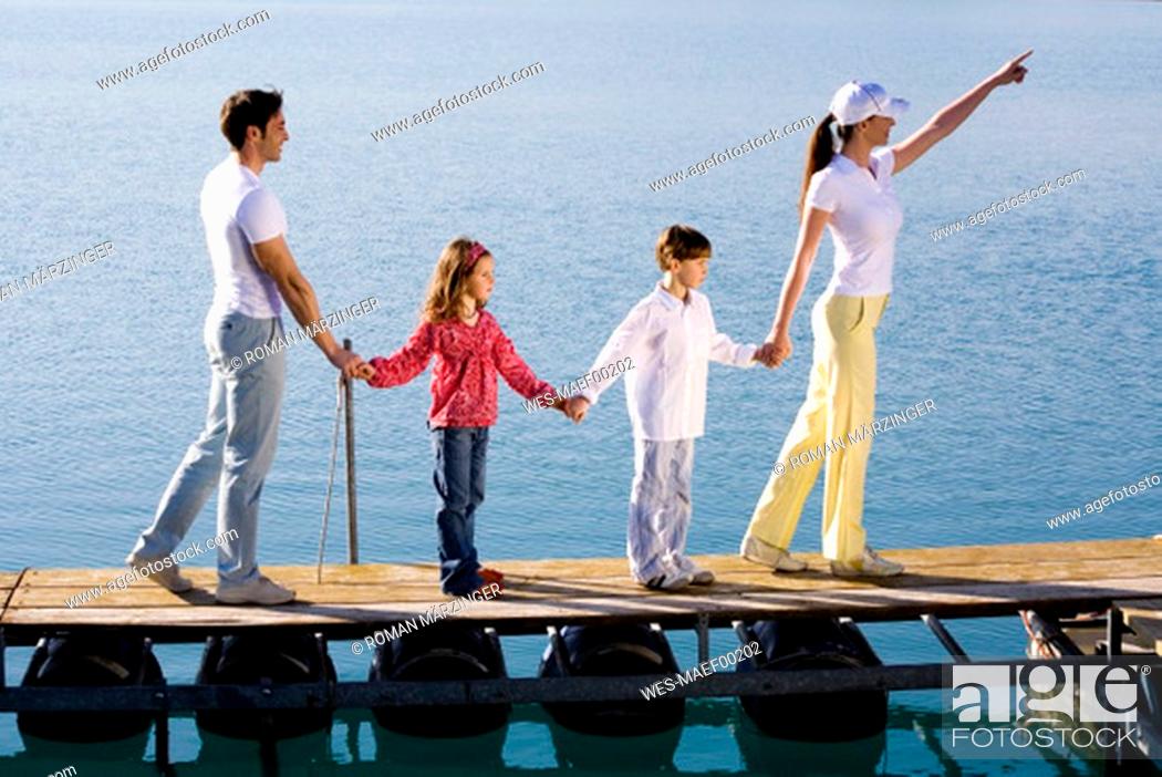 Stock Photo: Familiy standing on jetty, holding hands.