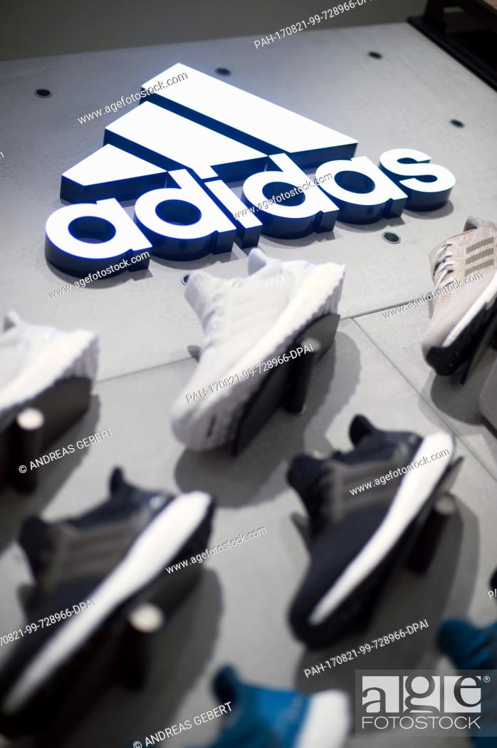 The logo of sporting company Adidas on a wall above Adidas shoes in a store Munich, Germany, Foto de Stock, Imagen Derechos Protegidos Pic. PAH-170821-99-728966-DPAI | agefotostock