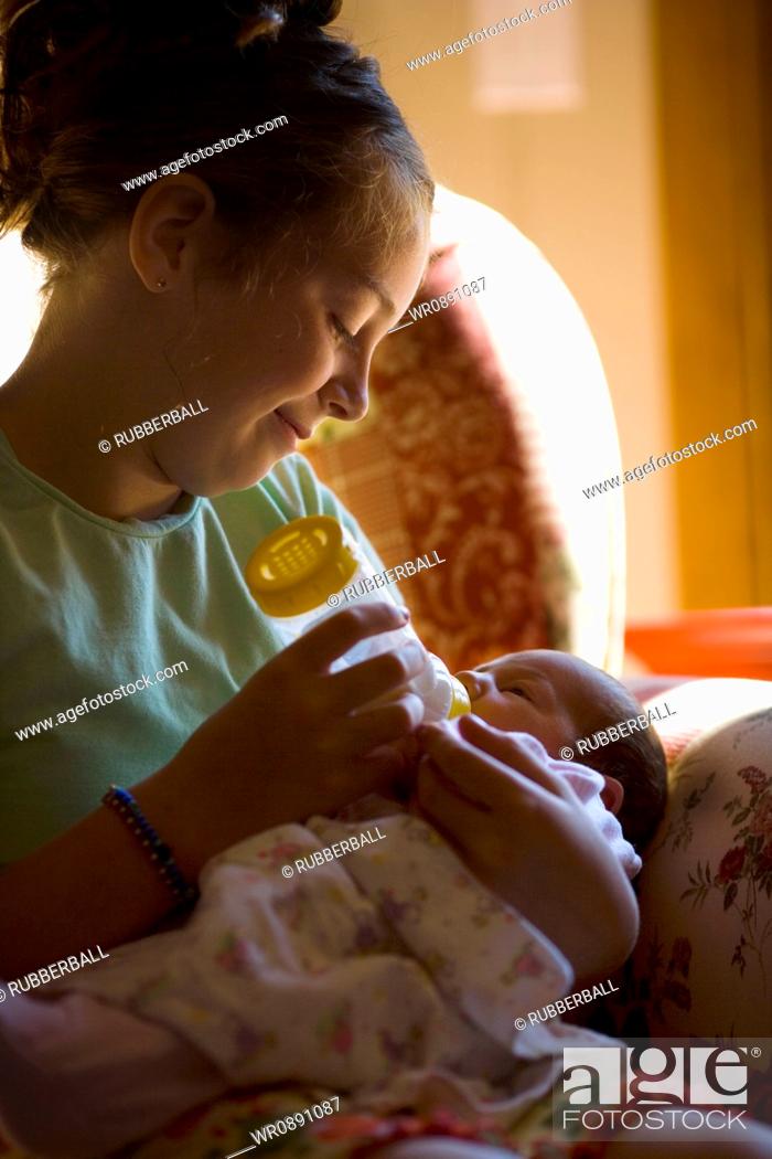 Stock Photo: Mother feeding her baby girl a bottle of milk.