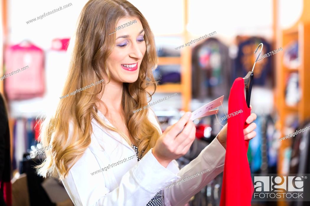 Stock Photo: Woman shopping in boutique or fashion store choosing clothes.